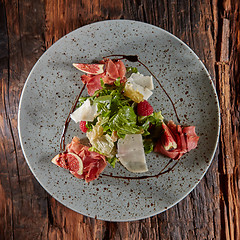 Image showing Fresh salad with figs, prosciutto and goat cheese