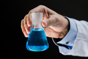 Image showing close up of scientist holding flask with chemical