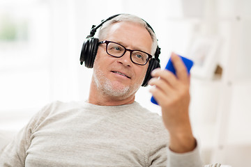 Image showing happy senior man with smartphone and headphones