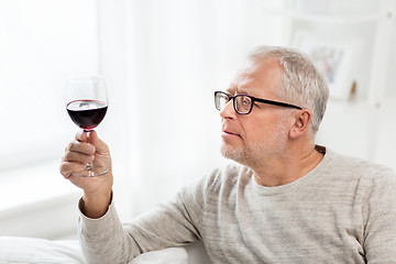 Image showing senior man drinking red wine from glass at home