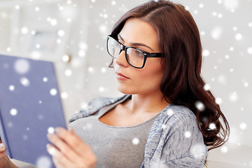 Image showing young woman in glasses reading book at home