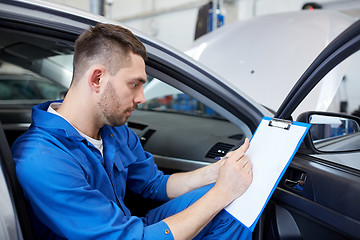 Image showing auto mechanic man with clipboard at car workshop