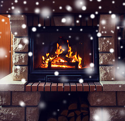 Image showing close up of burning fireplace with snow