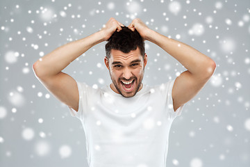 Image showing crazy shouting man in t-shirt over snow background