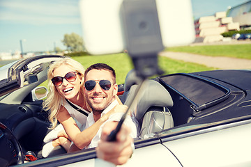 Image showing happy couple in car taking selfie with smartphone