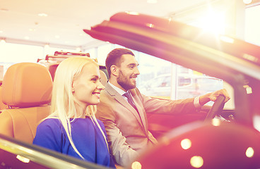 Image showing happy couple sitting in car at auto show or salon