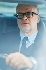 Image showing senior businessman driving car