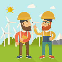 Image showing Two workers talking infront of windmills.