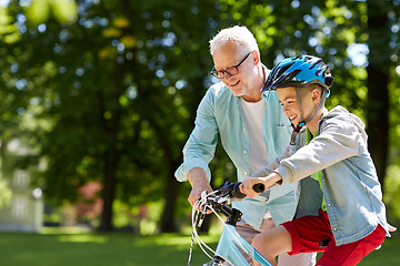 Image showing grandfather and boy with bicycle at summer park