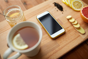 Image showing smartphone with cup of lemon tea, honey and ginger