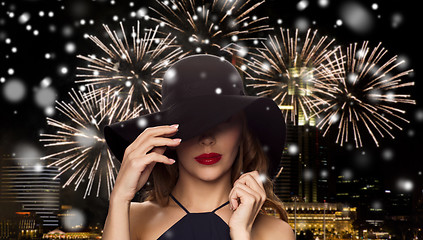 Image showing beautiful woman in black hat over night firework