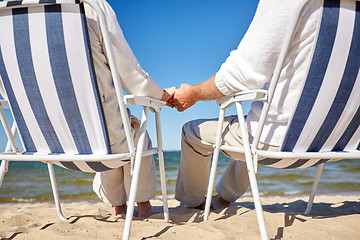 Image showing senior couple sitting on chairs at summer beach