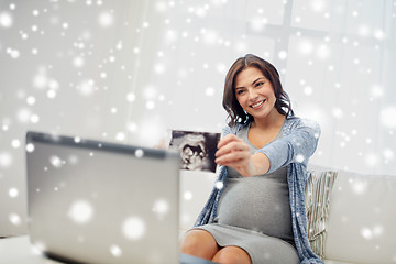 Image showing happy pregnant woman with ultrasound image at home