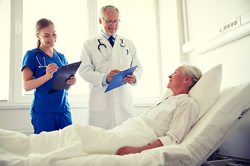 Image showing doctor and nurse visiting senior woman at hospital