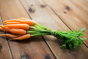 Image showing close up of carrot bunch on wooden table