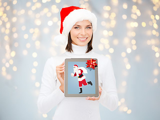 Image showing woman holding tablet pc with santa claus on screen