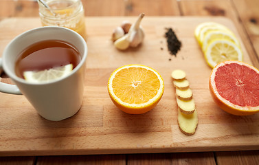 Image showing ginger tea with honey, citrus and garlic on wood