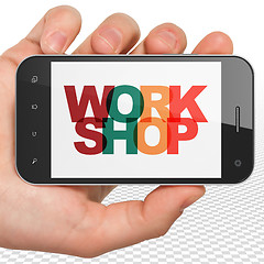 Image showing Education concept: Hand Holding Smartphone with Workshop on  display