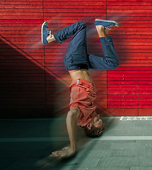 Image showing Break dancer doing handstand against colorful wall background