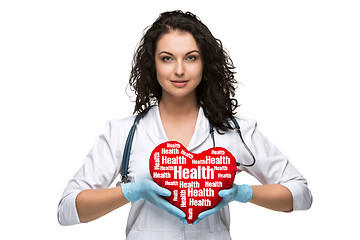 Image showing Pretty woman doctor holding a red heart