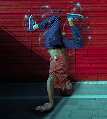 Image showing Break dancer doing handstand against colorful wall background