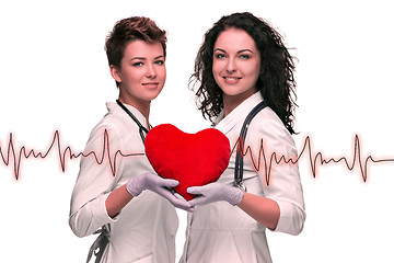 Image showing Two woman doctor holding a red heart