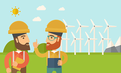 Image showing Two workers talking infront of windmills.