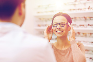 Image showing woman showing glasses to optician at optics store