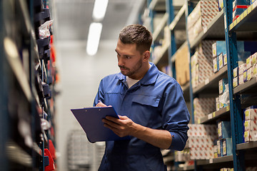 Image showing auto mechanic with clipboard at car workshop