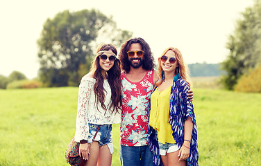 Image showing smiling young hippie friends on green field