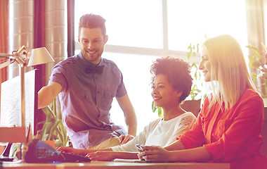 Image showing happy creative team with computer in office