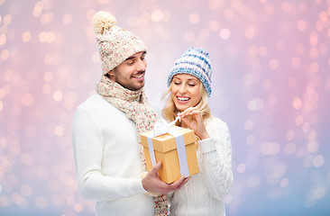 Image showing smiling couple in winter clothes with gift box