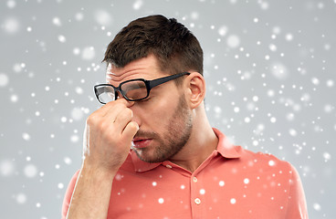 Image showing tired man with eyeglasses touching his nose bridge