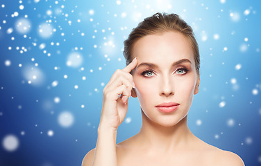 Image showing beautiful woman showing her forehead over snow