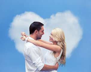 Image showing happy couple hugging over heart shaped cloud