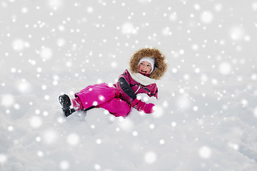 Image showing happy little kid or girl in winter clothes on snow