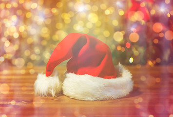 Image showing close up of santa hat on wooden table over lights