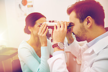 Image showing optician with pupilometer and patient at eye clinic