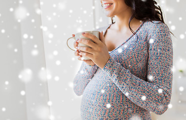 Image showing close up of pregnant woman with tea cup at window