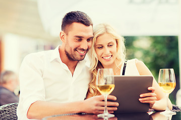 Image showing happy couple with tablet pc at restaurant lounge