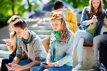 Image showing teenage friends with smartphones outdoors