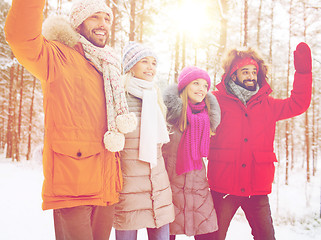 Image showing group of friends waving hands in winter forest