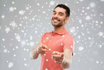 Image showing man pointing finger to you over snow background