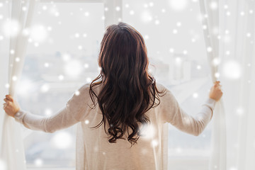 Image showing close up of woman opening window curtains