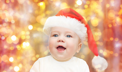 Image showing baby boy in christmas santa hat over blue lights
