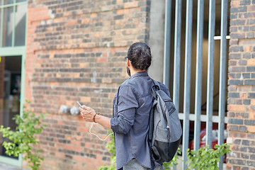 Image showing man with backpack and smartphone walking in city