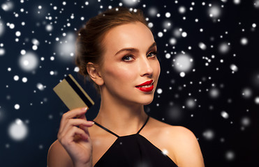 Image showing beautiful woman with credit card over snow