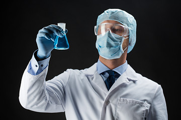 Image showing scientist in mask holding flask with chemical