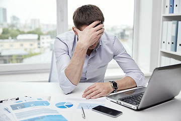 Image showing stressed businessman with papers in office