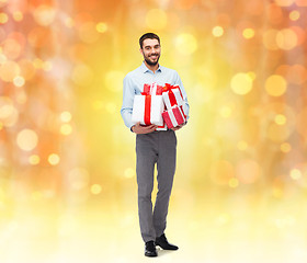 Image showing happy young man holding gift boxes